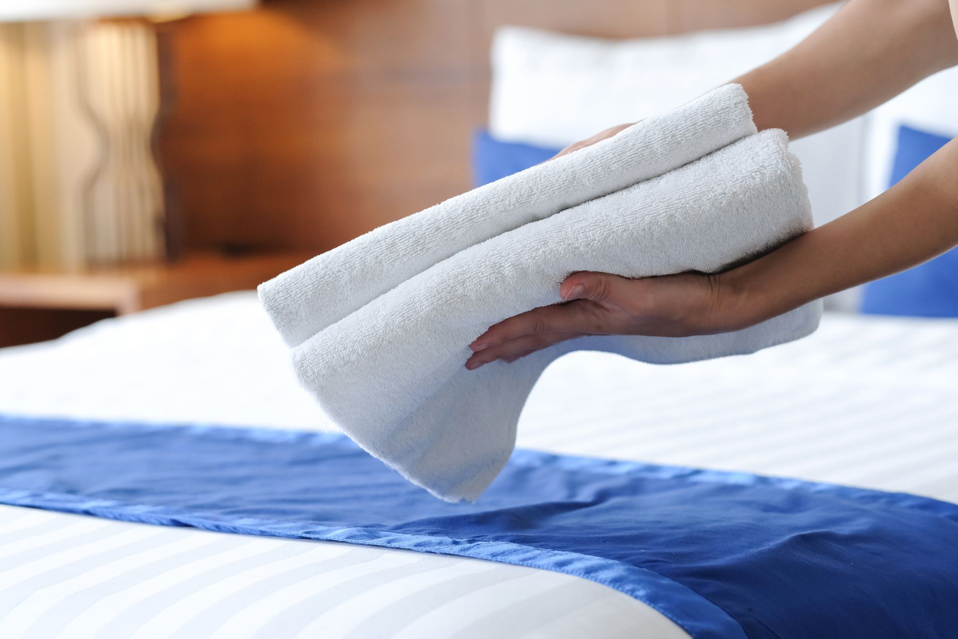 Hands of hotel maid bringing fresh towels to the room
